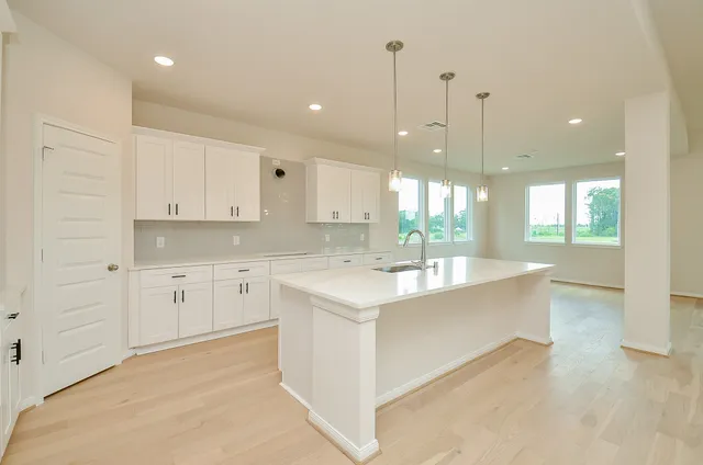 a view of an empty room with a kitchen
