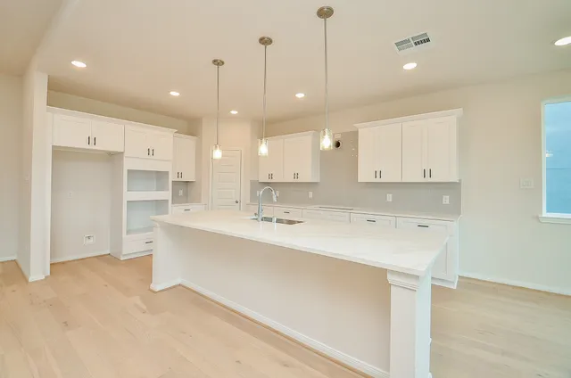 a large white kitchen with a large window