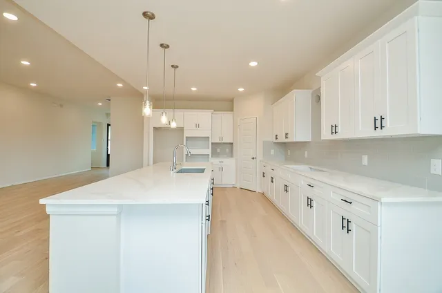 a large kitchen with kitchen island a sink stainless steel appliances and cabinets