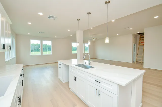 a kitchen with kitchen island a sink stainless steel appliances and cabinets