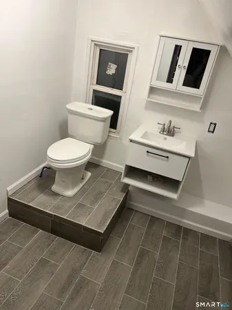 a bathroom with a sink toilet and mirror