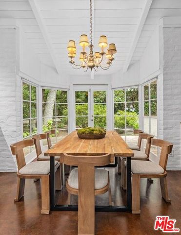 a view of a dining room with furniture a chandelier and wooden floor