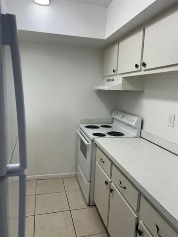 a view of a kitchen with white cabinets