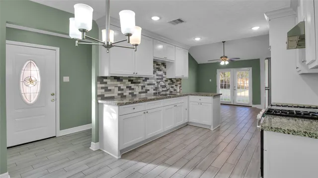 a large kitchen with stainless steel appliances a large counter top a stove and a refrigerator