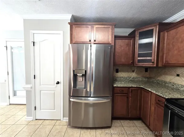 a kitchen with stainless steel appliances granite countertop a refrigerator and a stove top oven