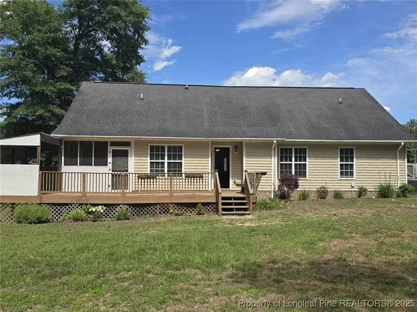 a front view of a house with a garden and trees