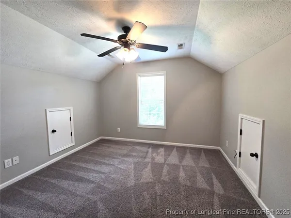 an empty room with a ceiling fan and wooden floor