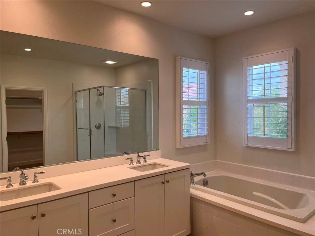 119 Alumroot Irvine, CA 92620 - Photo 15 of 35 a bathroom with a sink double vanity granite tub shower and a mirror