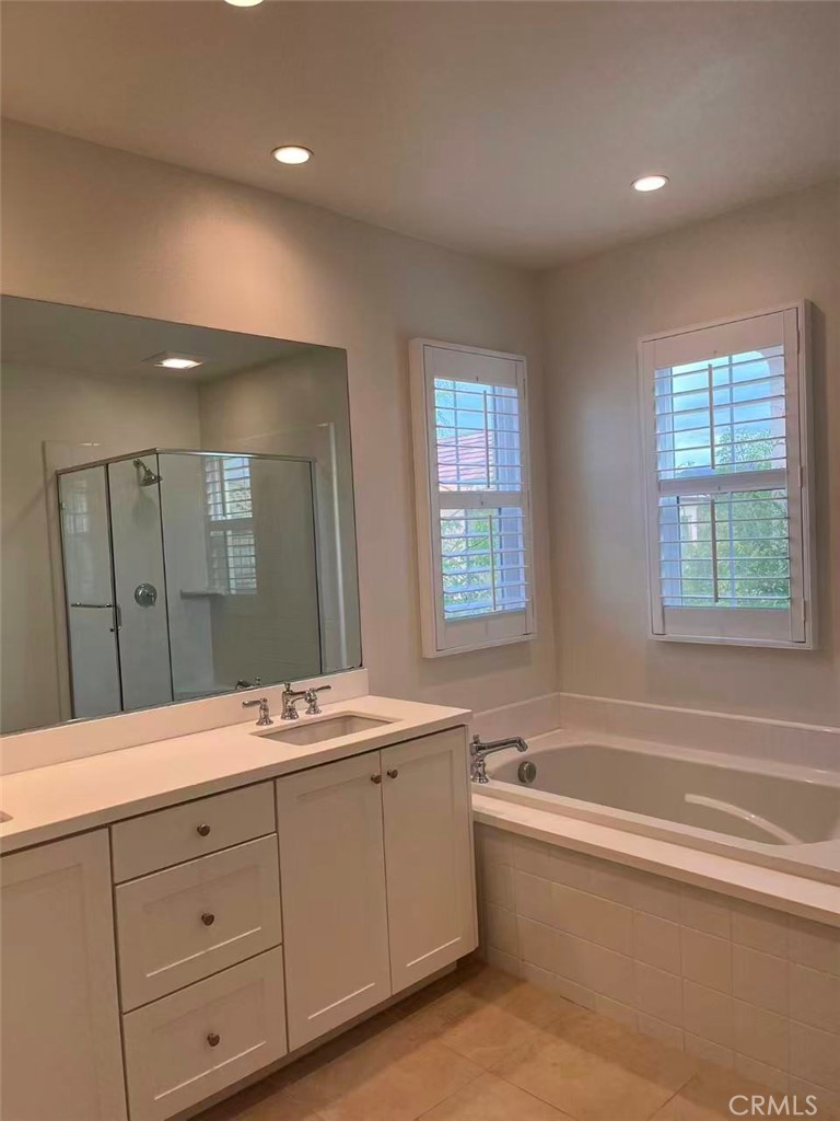 119 Alumroot Irvine, CA 92620 - Photo 17 of 35 a spacious bathroom with a tub double sink window and mirror