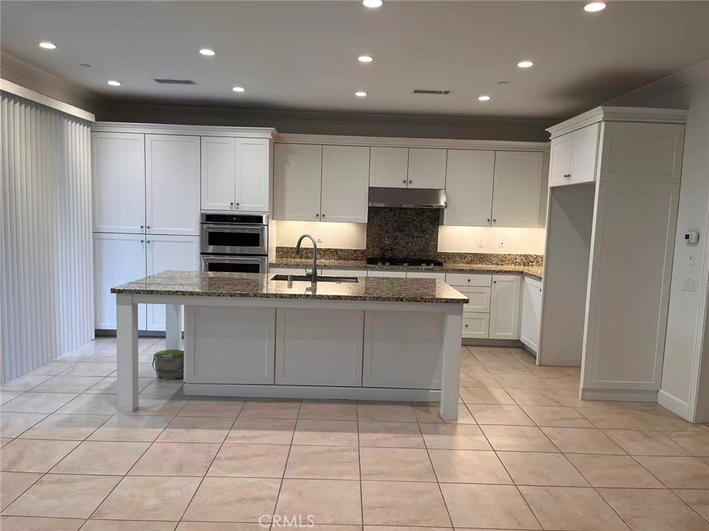 119 Alumroot Irvine, CA 92620 - Photo 6 of 35 a kitchen with kitchen island granite countertop appliances cabinets and a sink