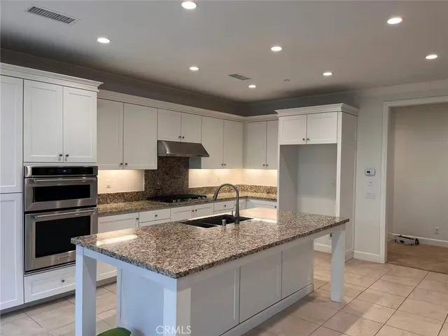 a kitchen with granite countertop a sink and stainless steel appliances