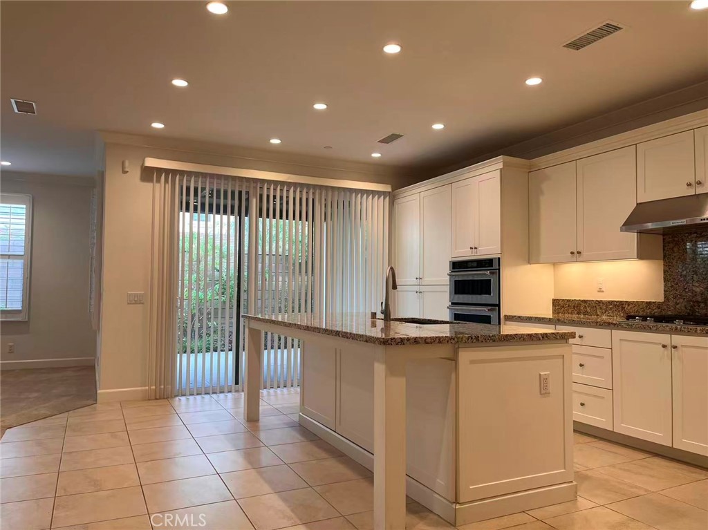 119 Alumroot Irvine, CA 92620 - Photo 9 of 35 a kitchen with kitchen island granite countertop a stove and a sink