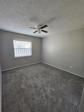 an empty room with a empty space and a ceiling fan