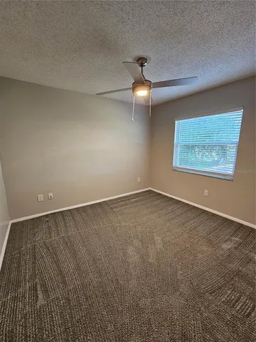 an empty room with a projector and fan