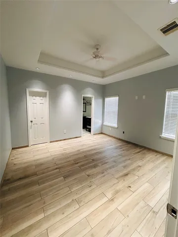 a view of empty room with window and wooden floor