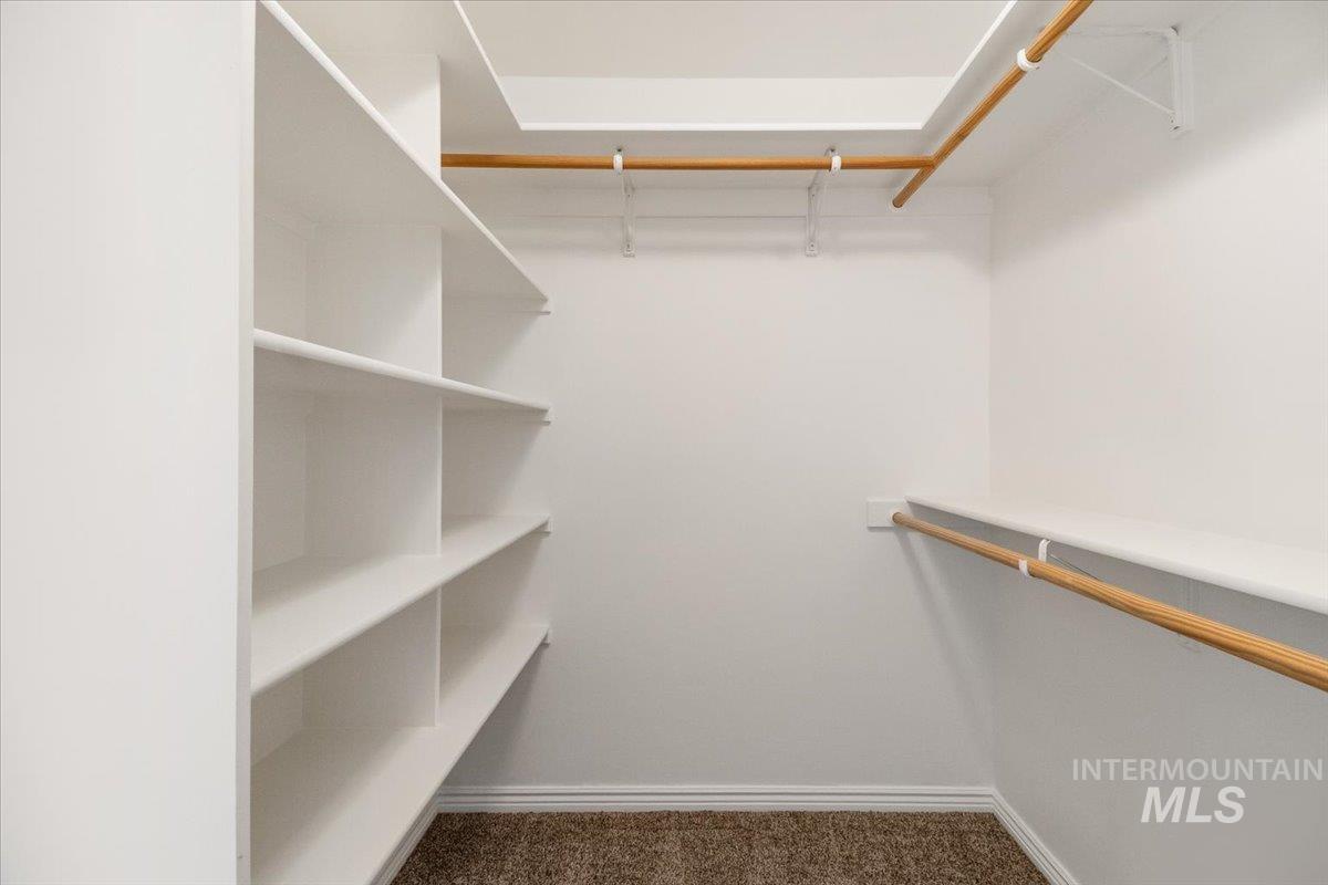 2032 Talus Loop Twin Falls, ID 83301 - Photo 38 of 43 Walk-in closet featuring built-in shelving, two hanging rods, and neutral-toned carpeting