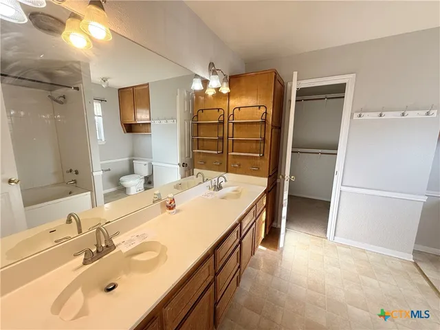 a bathroom with a tub sink and mirror