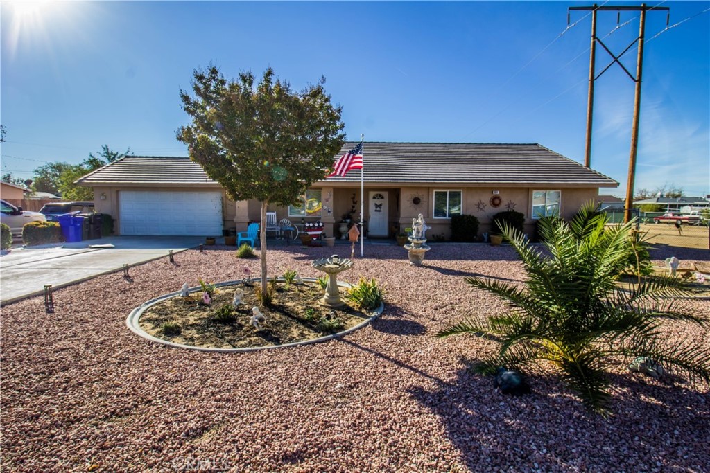 11894 Puye Road Apple Valley, CA 92308 - Photo 1 of 1 a front view of a house with garden