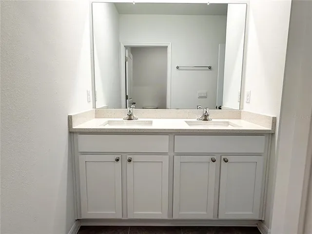 a bathroom with a sink vanity granite and a mirror
