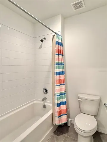a white toilet sitting next to a bath tub and a shower