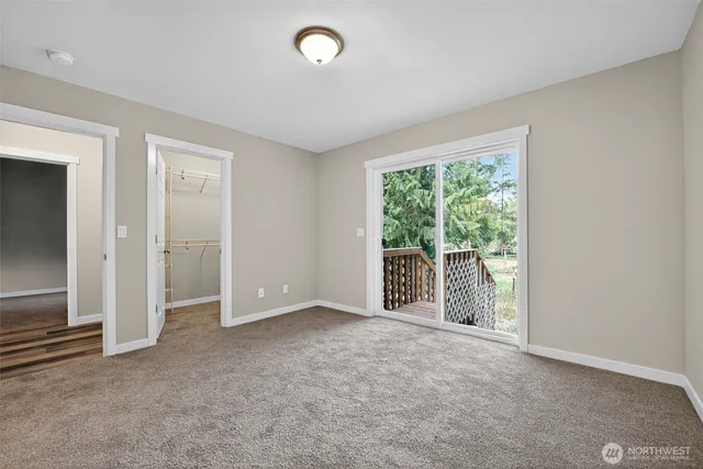 an empty room with large window and closet area