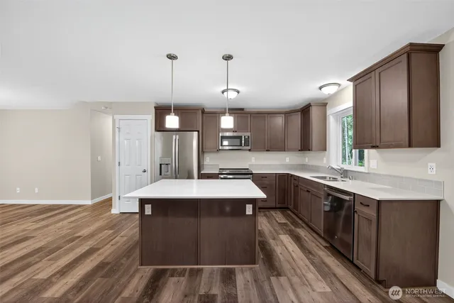 a large kitchen with kitchen island a sink stainless steel appliances and cabinets