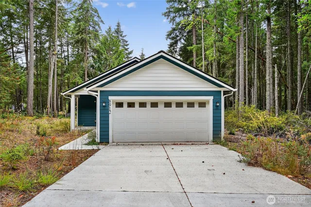 a front view of a house with a garden and trees