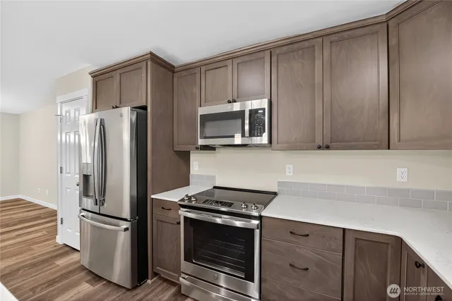 a kitchen with granite countertop a refrigerator stove and microwave