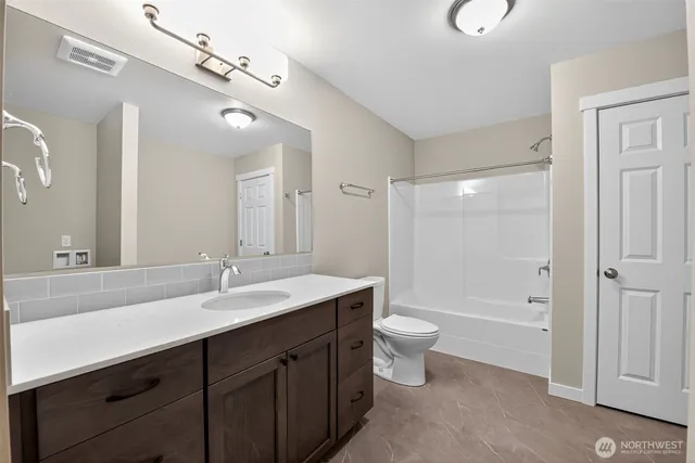 a bathroom with a double vanity sink toilet mirror and bathtub