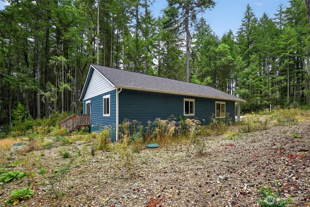a backyard of a house with large trees and brick wall