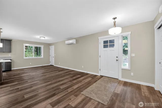 an empty room with wooden floor window and fireplace