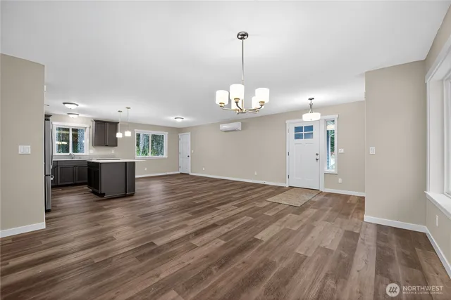 a view of a big room with wooden floor kitchen and windows