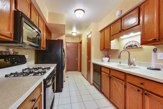 a kitchen with stainless steel appliances a sink stove and cabinets