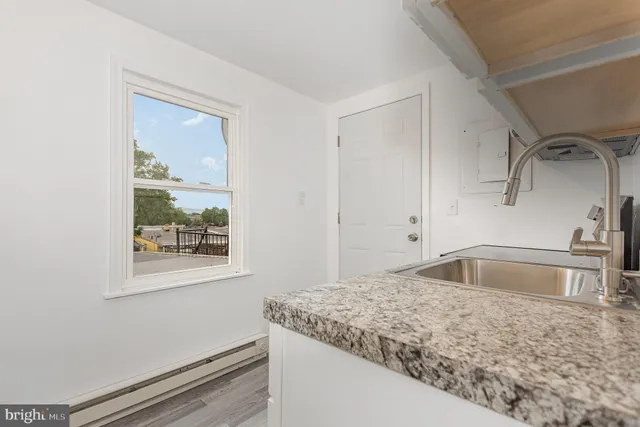 a bathroom with a granite countertop sink and a window