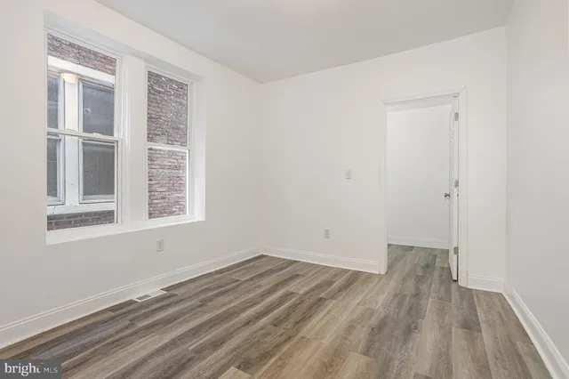 a view of a room with wooden floor and windows