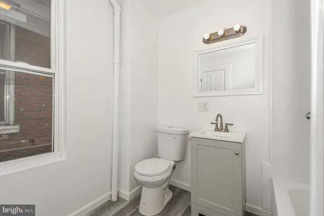 a bathroom with a toilet a sink and mirror