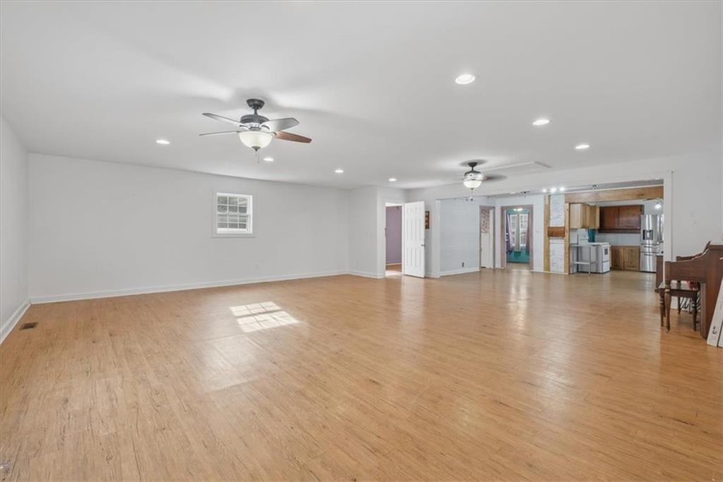 1491 Booze Mountain Road Silver Creek, GA 30173 - Photo 8 of 41 an empty room with wooden floor chandelier fan and outdoor view