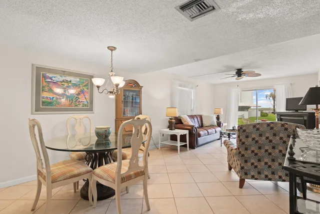 a dining room with furniture a chandelier and wooden floor
