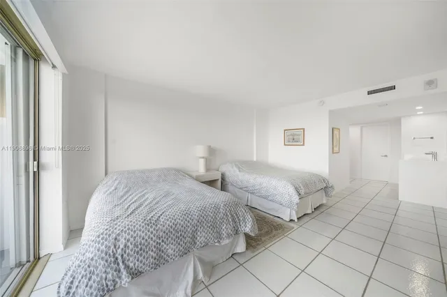 a bedroom with two beds and a lamp on the dresser