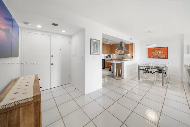 a kitchen with stainless steel appliances kitchen island granite countertop a refrigerator and a stove top oven