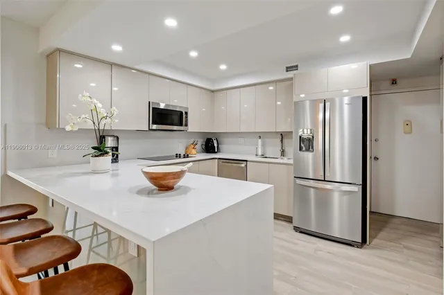 a kitchen with stainless steel appliances a stove a sink a refrigerator and a refrigerator