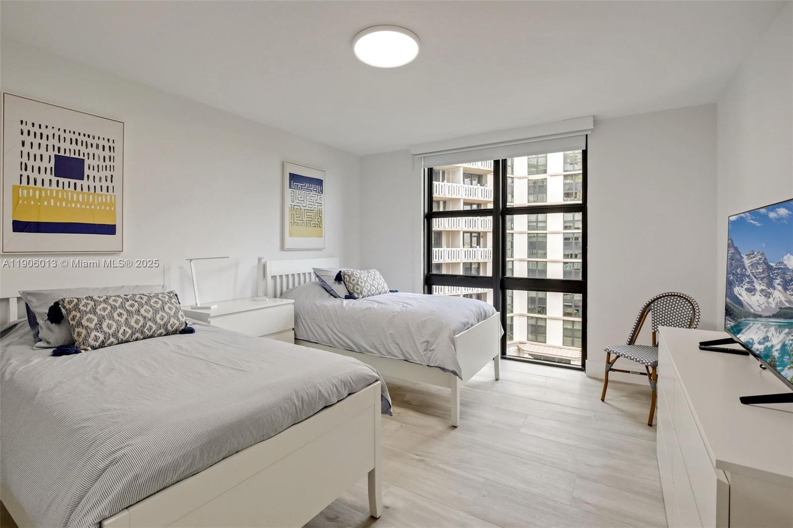 1111 Crandon Boulevard, Unit A507 Key Biscayne, FL 33149 - Photo 8 of 23 a bedroom with two beds and a large mirror next to a window