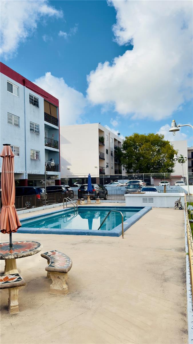 6070 West 19th Avenue, Unit 307 Hialeah, FL 33012 - Photo 14 of 19 a view of a swimming pool with a patio