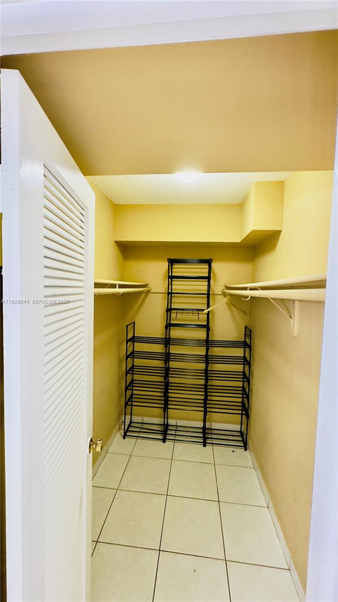6070 West 19th Avenue, Unit 307 Hialeah, FL 33012 - Photo 17 of 19 a view of walk in closet with clothes