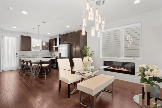 a living room with furniture kitchen view and a chandelier