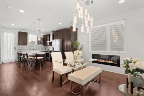 a living room with furniture kitchen view and a chandelier
