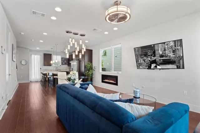 a living room with furniture kitchen view and a chandelier