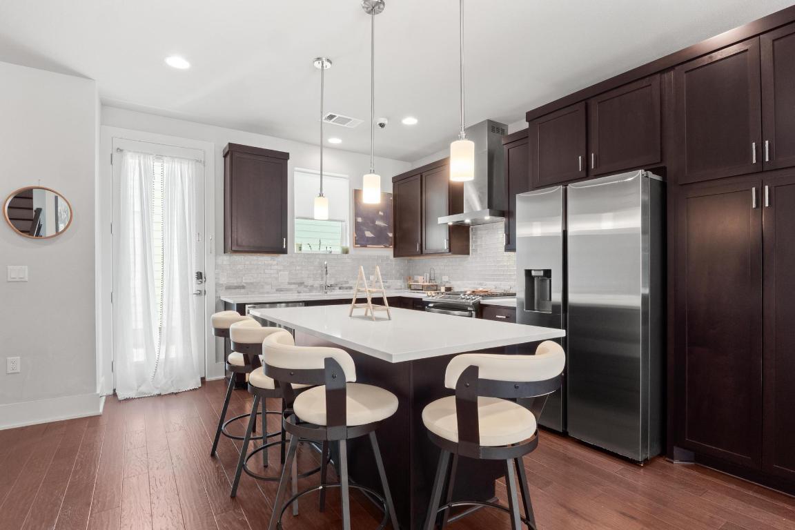 7924 Yellow Thistle Trail, Unit 39 Austin, TX 78735 - Photo 8 of 26 a kitchen with stainless steel appliances a dining table chairs refrigerator and sink