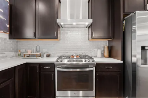 a kitchen with granite countertop a sink stainless steel appliances and cabinets