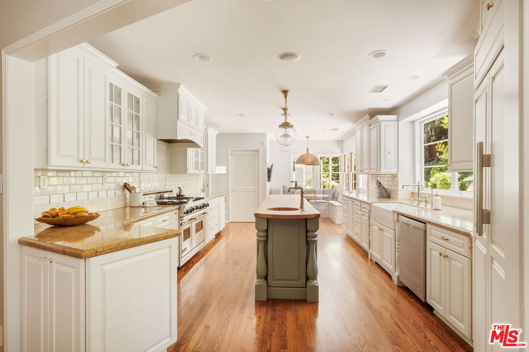 1265 Inverness Drive Pasadena, CA 91103 - Photo 19 of 56 a kitchen with stainless steel appliances a stove sink and cabinets